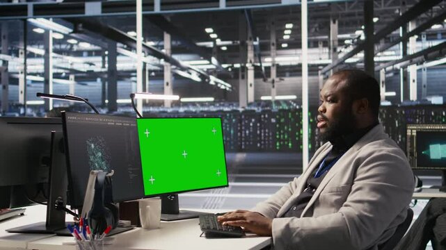 Data center programmer coding on green screen PC, monitoring AI systems. Server hub IT expert uses mockup computer to oversee rackmounts powering deep learning processes, camera A