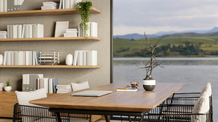 Closed laptop and coffee cup on wooden table in living room with river or lake view outside the door