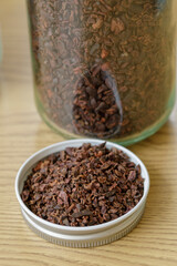 Pile of instant granulated cocoa nibs on a wooden table