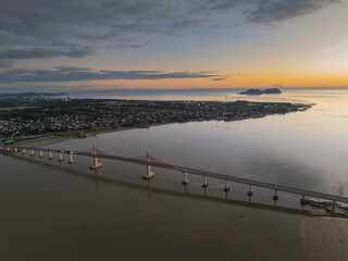 Cua Hoi bridge stretches over Vinh city's river at dusk, showcasing its elegant design and the nearby landscape
