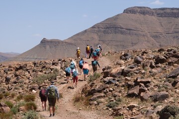 Amazing mountain landscapes of Jebel Saghro with volcanic rocks eroded by wind and time and group of trekking tourists. Atlas, Anti Atlas, Morocco © Iwona