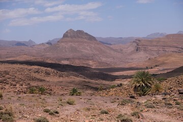 Amazing mountain landscapes of Jebel Saghro with volcanic rocks eroded by wind and time and palm trees. Atlas, Anti Atlas, Morocco