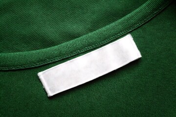 Blank White Clothing Label on Green Cotton Fabric Texture