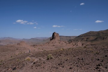 Amazing mountain landscapes of Jebel Saghro with volcanic rocks eroded by wind and time and little silhouette of single man. Atlas, Anti Atlas, Morocco © Iwona