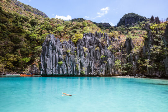 Woman swimming in the turquoise water of a lagoon, El Nido, Philippines