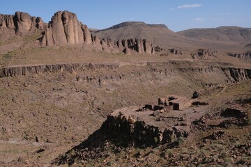 Amazing mountain landscape of Jebel Saghro with volcanic rocks eroded by wind and ruined settlement with buildings. Atlas, Anti Atlas, Morocco © Iwona