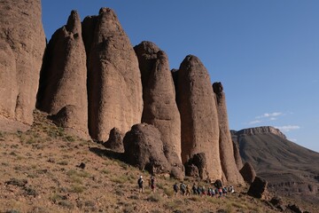 Amazing mountain landscapes of Jebel Saghro with volcanic rocks eroded by wind and time and group of trekking tourists. Atlas, Anti Atlas, Morocco © Iwona