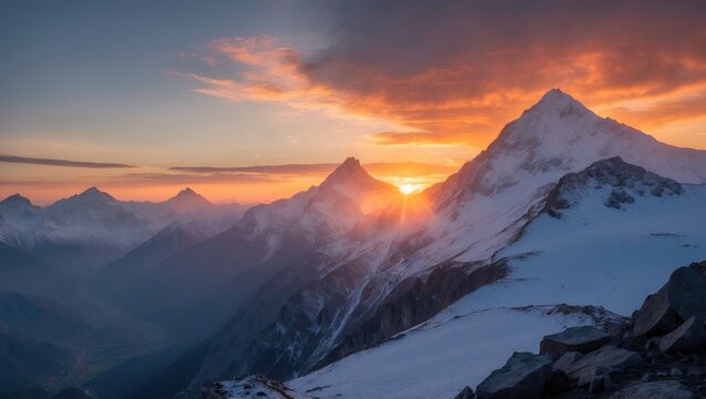 Sunset over snowy mountains with peaks and clouds, capturing a scenic mountain landscape at dusk.