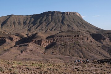 Amazing mountain landscapes of Jebel Saghro with volcanic rocks eroded by wind and time and group of trekking tourists. Atlas, Anti Atlas, Morocco © Iwona