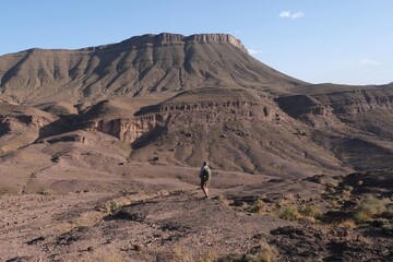 Amazing mountain landscapes of Jebel Saghro with volcanic rocks eroded by wind and time and little silhouette of single man. Atlas, Anti Atlas, Morocco © Iwona