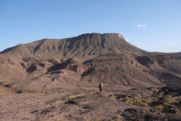 Amazing mountain landscapes of Jebel Saghro with volcanic rocks eroded by wind and time and little silhouette of single man. Atlas, Anti Atlas, Morocco © Iwona