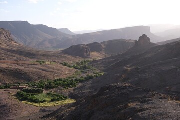Amazing mountain landscapes of Jebel Saghro with volcanic rocks eroded by wind and time and  settlement with buildings. Atlas, Anti Atlas, Morocco © Iwona