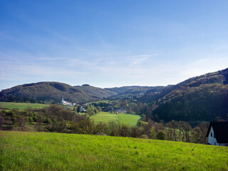 village with typical church in german suedeifel under blue sky in spring