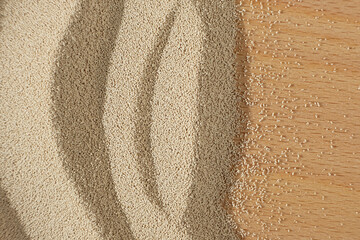 Dry yeast scattered on wooden surface, copy place for text.