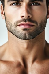 Obraz premium Portrait of a male model with chiseled features and a strong jawline against a neutral background in a contemporary studio setting