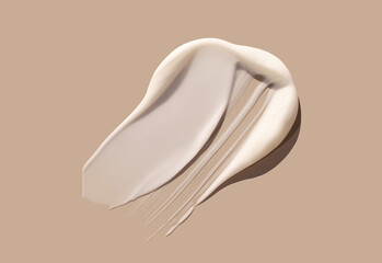 sample smear of creamy white texture on light beige background close up