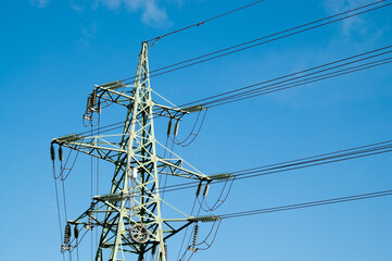 power transmission line support and wires against blue sky close-up