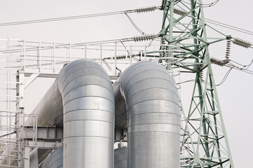 pipeline and power line against gray sky