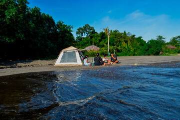 A relaxing family picnic scene by the beach with waves softly reaching the shore