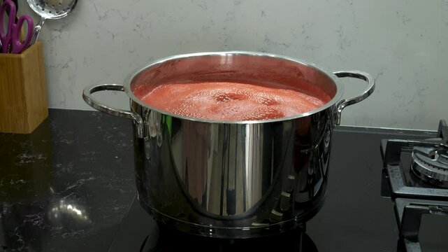 Footage of tomatoes being cooked for canning.