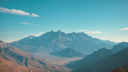 Fototapeta premium Mountain landscape with rugged terrain and peaks under a blue sky. Nature and wilderness, concept. Mountain and outdoor adventure. The concept of mountain exploration and scenery