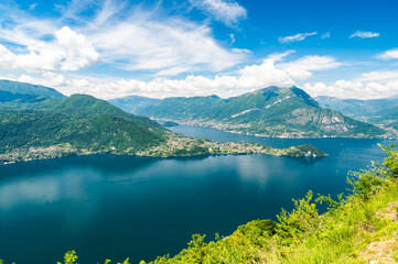 Panorama of Lake Como photographed at Alpe Mezzedo in Esino Lario, showing Bellagio, Balbianello, the Lecco and Como shores of the lake and the mountains above.
