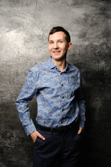 Obraz premium A Confident and Happy Smiling Man Posing Stylishly in a Modern, Trendy Blue Shirt