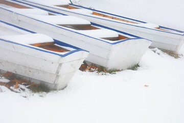 wooden white and blue boats on background snow