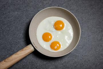 Drei Spiegeleier in Bratpfanne von oben fotografiert