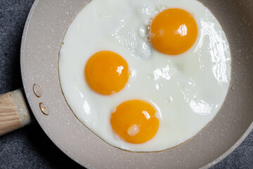 Drei Spiegeleier in Bratpfanne von oben fotografiert