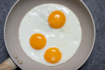 Drei Spiegeleier in Bratpfanne von oben fotografiert