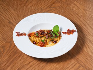 Gourmet Spaghetti Pasta with Bacon and Herbs on White Plate
