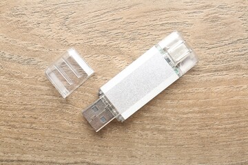 One flash drive on wooden background, top view