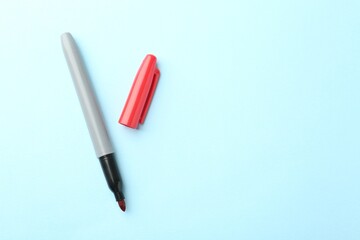 One red marker on light blue background, top view. Space for text