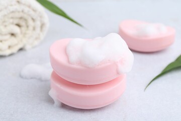 Soap bars with foam on white table, closeup