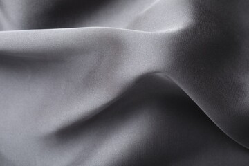 Crumpled grey silk fabric as background, closeup