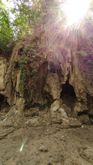 Sun shining over travertine rocks and small cave in krka national park