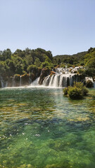 Obraz premium Waterfalls flowing into green lake in krka national park, croatia