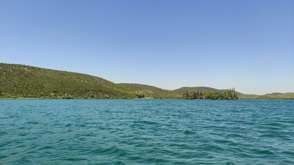 Visovac monastery island on krka river reflecting on turquoise water in croatia