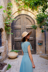 A stunning young woman with amazing looks walks along a beautiful street in the old city of Jaffa....