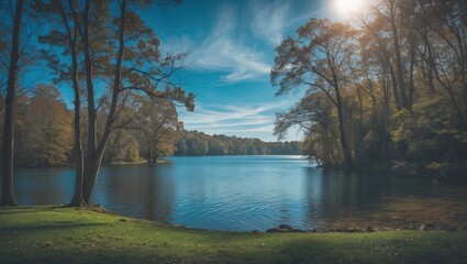 Obraz premium Serene river scene with trees and blue sky, peaceful nature landscape, tranquil water, and lush greenery during daylight.