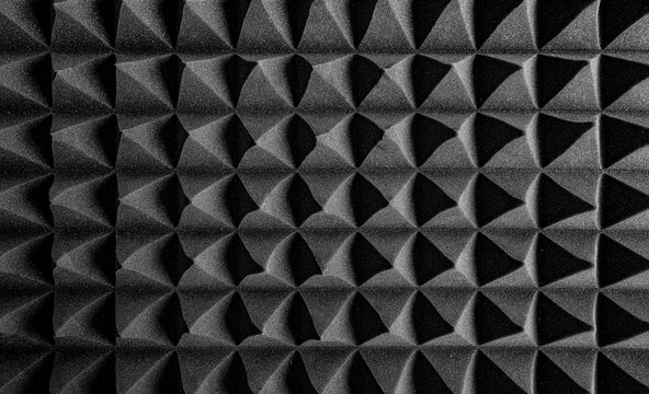 Black acoustic foam panels arranged in a sharp, geometric pattern designed to absorb sound and reduce echo in studio environments.
