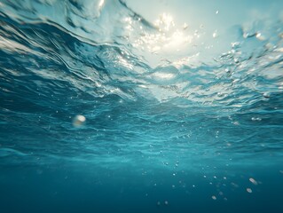 A serene underwater view with light blue tones and sunlight streaming through the surface