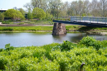 Fototapeta premium Scenic park view with modern bridge and pond.