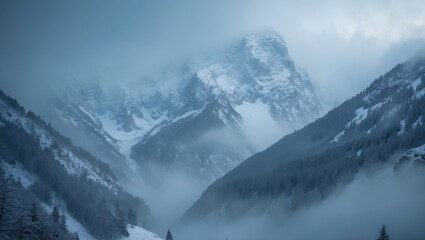 Obraz premium Snow-covered mountains and foggy valleys in a winter landscape. Mountain scenery and weather conditions. Nature and outdoor environment. The scene of rugged mountain terrain.