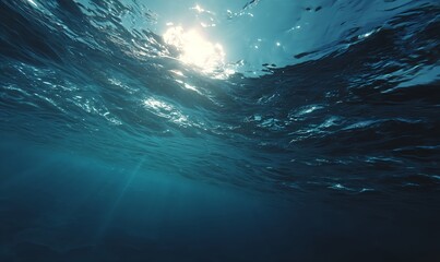 Serene ocean depths tinted pale blue, pierced by shafts of sunlight from the surface