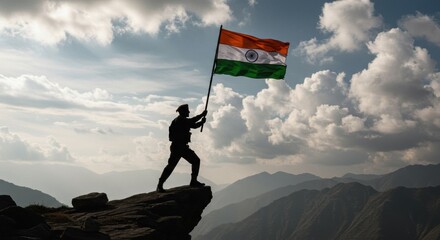 Heroic silhouette of soldier holding Indian flag atop mountain ridge at sunset