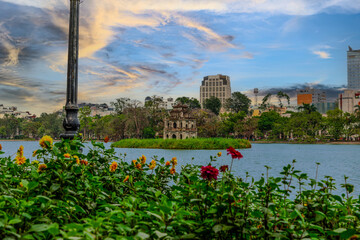 Lake in Hanoi Old Commercial Shops and Apartment house block in Hanoi Old Quarters Vietnam. Trees...