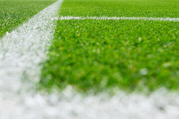 Close-up view of corner line, football, soccer field, with sharp white markings on well-maintained green grass.