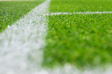Close-up view of corner line, football, soccer field, with sharp white markings on well-maintained green grass.